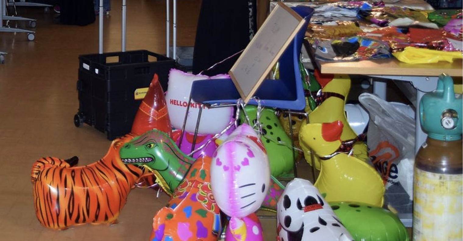 Various children's balloons under a table.